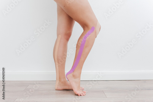 Women legs with tapes. Taping on legs. Kinesiology taping concept.