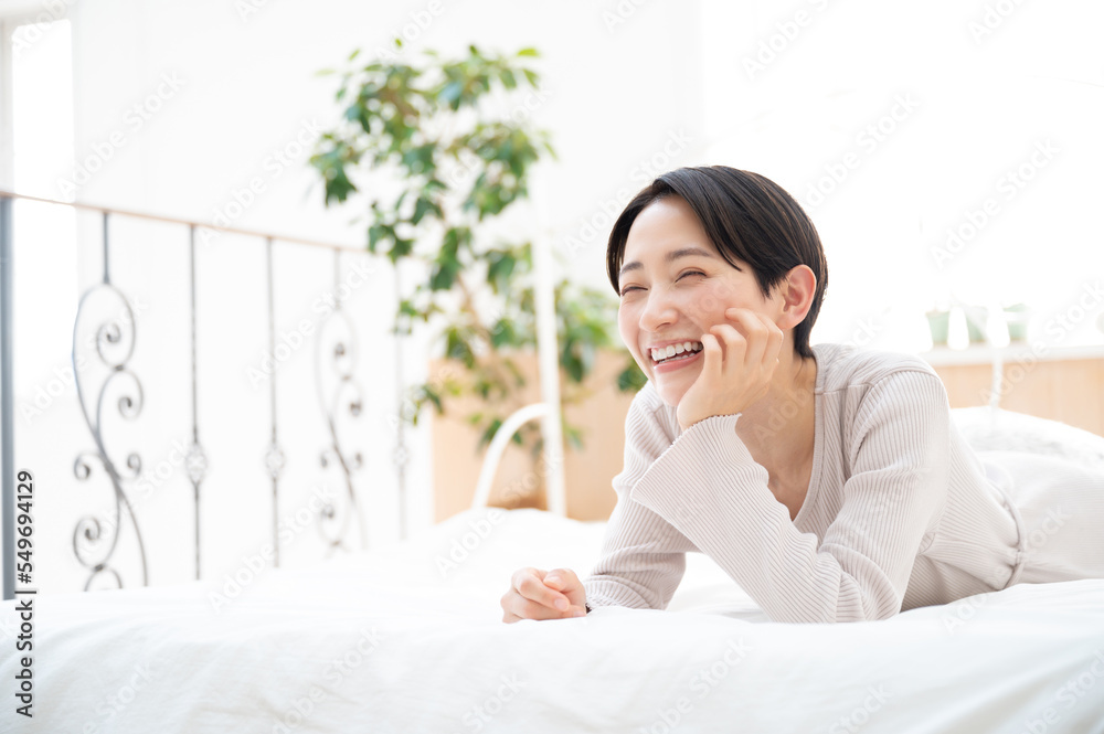 Beautiful smiling Asian woman lying down and smiling Beautiful smiling Asian woman lying down and smiling