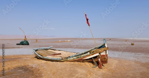 Salt lake in Tunisia Chott el Djerid during a sunny windy day. Largest salt lake in the Sahara Desert. Tourist destination. Travel the world. Boat on the dry lake. Mysterious landscape. 