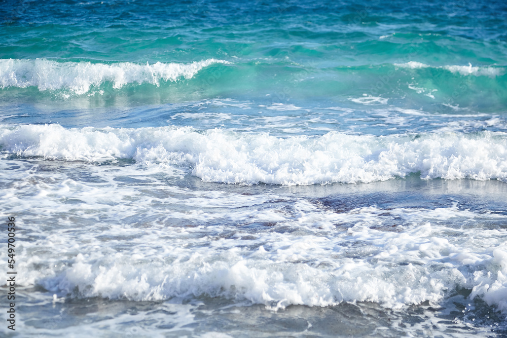 Summer sea water with white waves. Empty sand beach with azure water. Summer holiday background