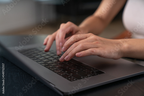 Businesswoman wearing casual wear is sitting typing on laptop