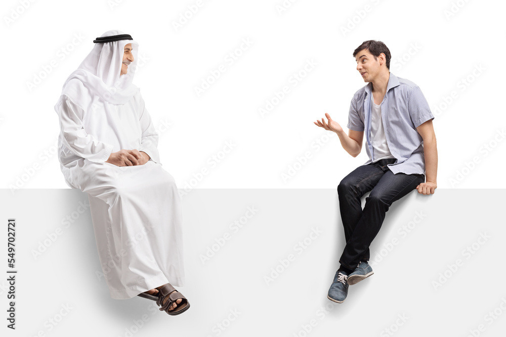 Casual guy sitting on a white panel and talking to a mature arab man