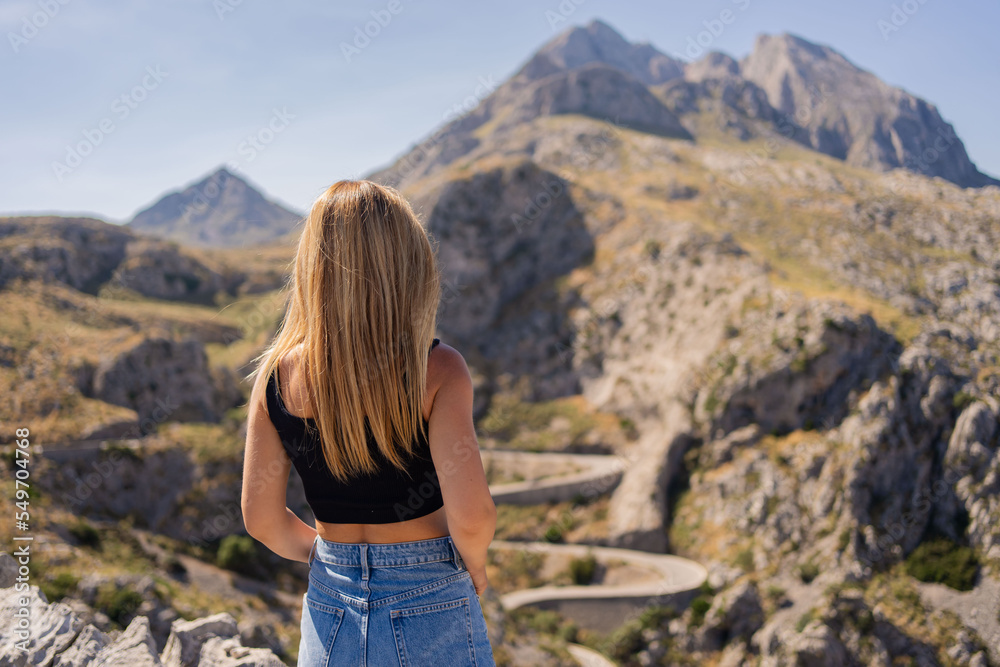 Naklejka premium Young woman hiking in mountains in Mallorca island. Enjoy the freedom. Palma de Mallorca, Tramuntana.