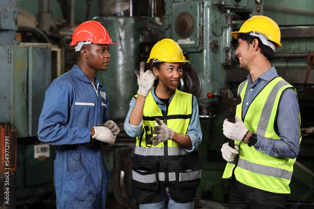Group of technician engineer team working together discussing, brainstorming and planning work while controll or maintenance operation work lathe metal machine at heavy industry manufacturing factory