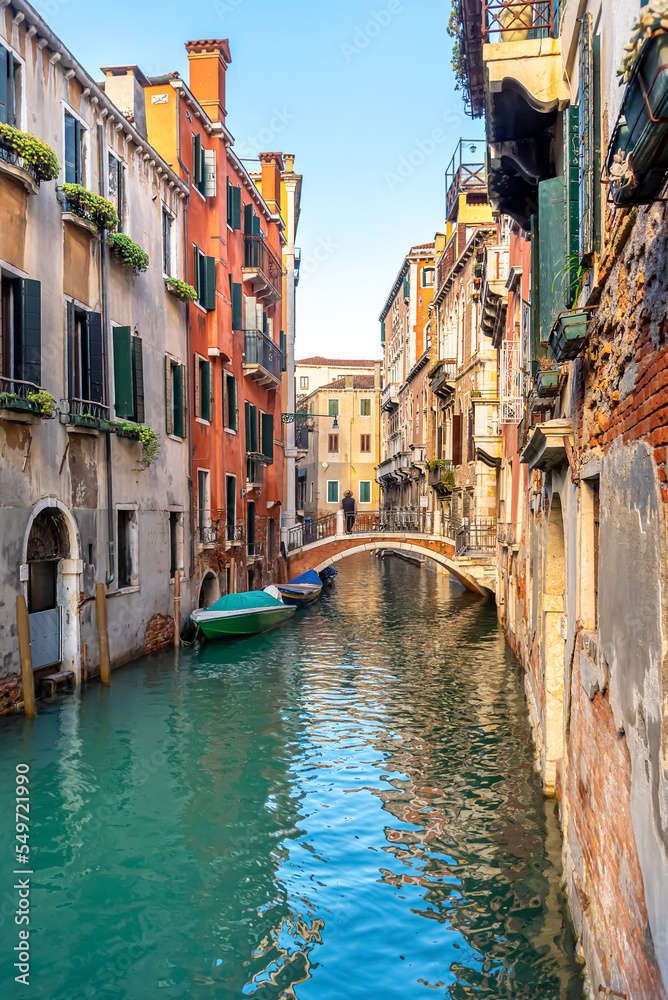 View of the narrow canal of Venice, old houses, bridge and gondolas
