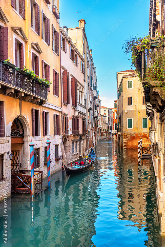 Obraz premium View of the narrow canal of Venice, old houses, bridge and gondolas