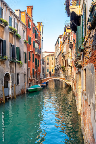 Leinwand Poster View of the narrow canal of Venice, old houses, bridge and gondolas