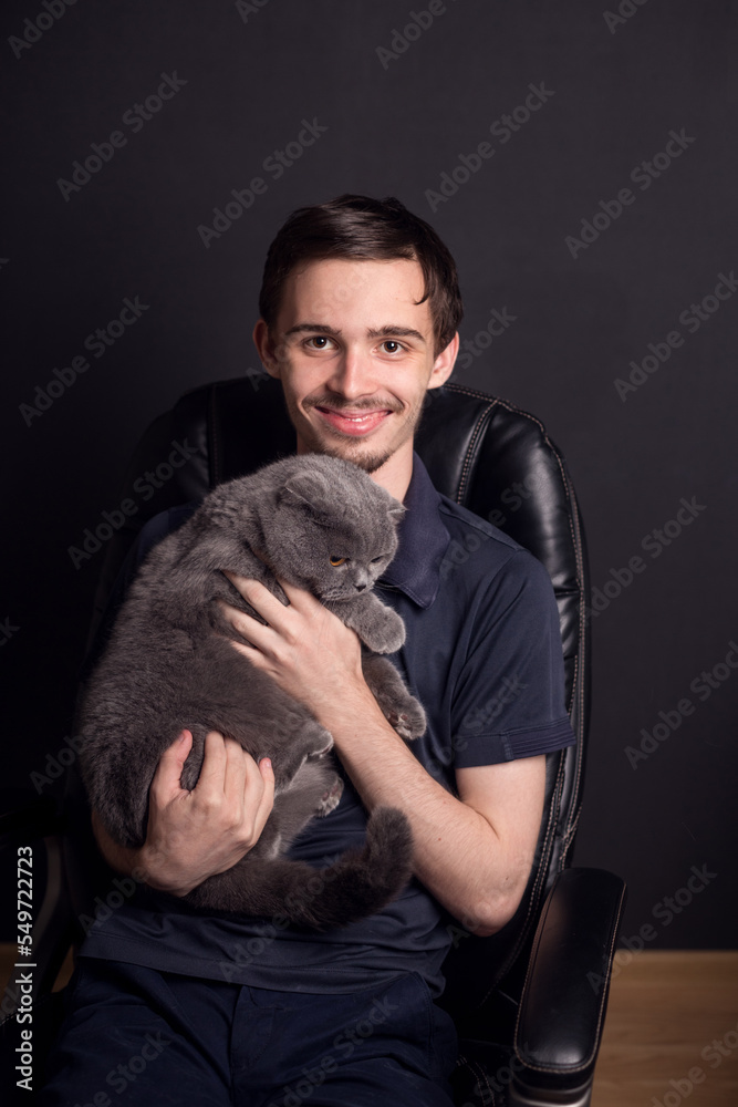 emotions of a young man who holds his beloved cat in his arms. emotions of a young man who holds his beloved cat in his arms.