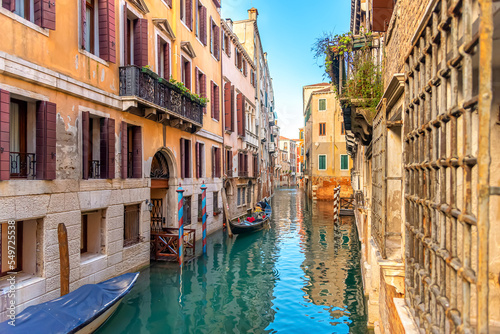 View of Venice narrow canal, old houses and gondola