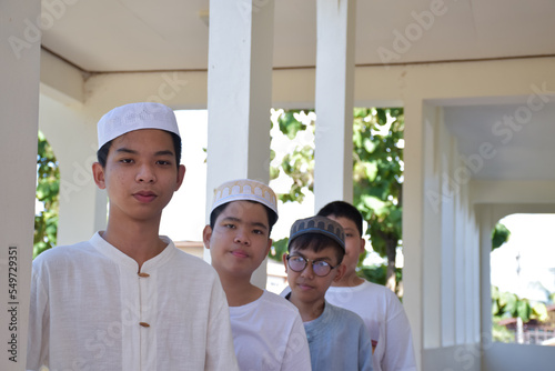 Young southeast asian children standing in a row in front of balcony and waiting to do their daily activity, soft and selective focus.