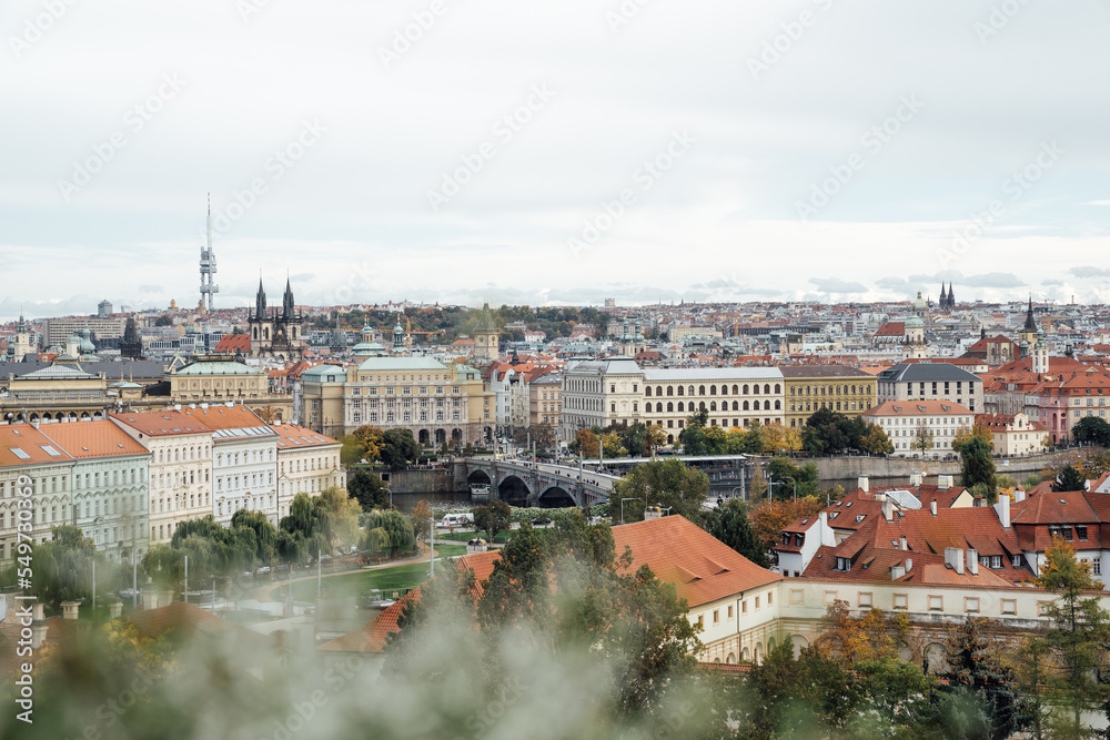 Prague cityscape with view of Nicholas Cathedral and orange building roofs in autumn
