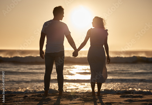 Beach silhouette  couple holiday and sunset with love  hold hands and love together  support and holiday. Man  woman and vacation at ocean  travel and romance for anniversary  honeymoon and sea trip