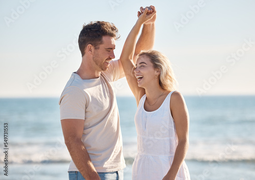 Beach, love and dance with a young couple in nature, happy together during a date or summer vacation. Smile, travel and romance with a man and woman dancing by the sea or ocean while bonding