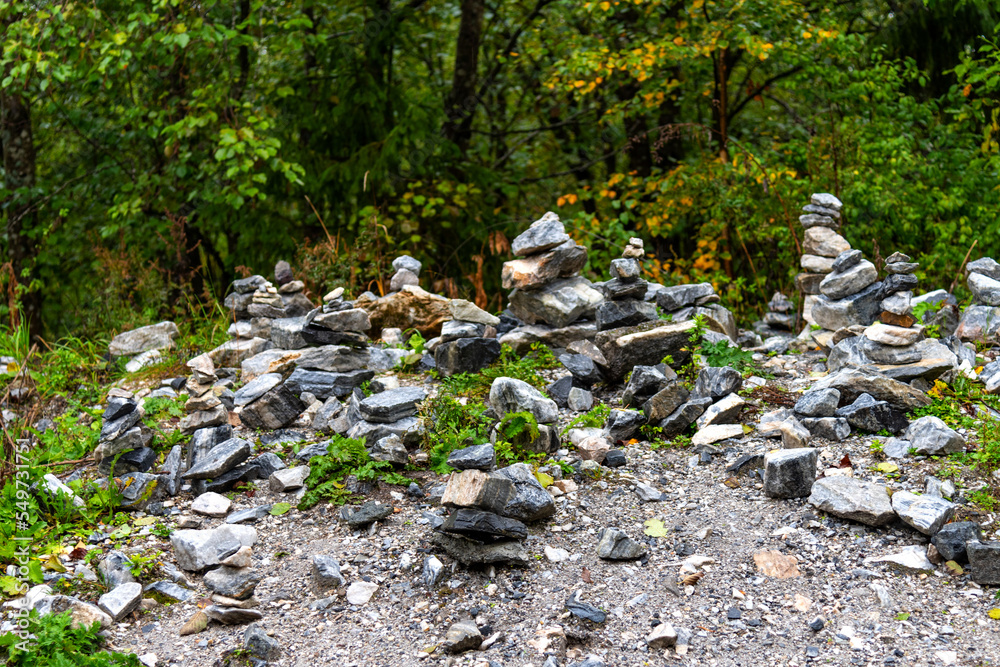 Pyramids of stones in Karelia. Pyramids of stones on background of green forest. Natural stones on top of each other. Balancing stones in the forest.