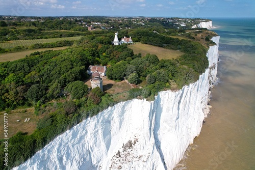 House and old lighhouse close to edge of white cliffs of Dover Kent UK drone aerial view photo