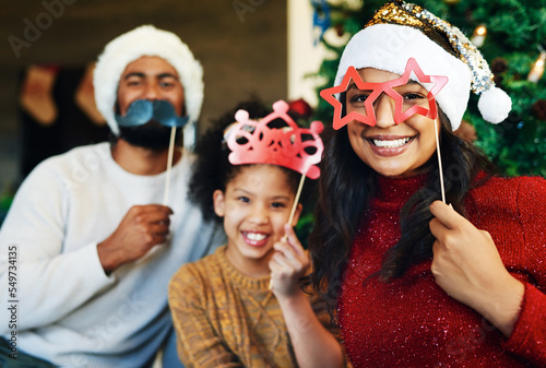 Christmas, props and portrait of girl with family celebration with happy of mom, father and kid love together at home. Xmas vacation party, holiday bonding and mother with child smile in living room