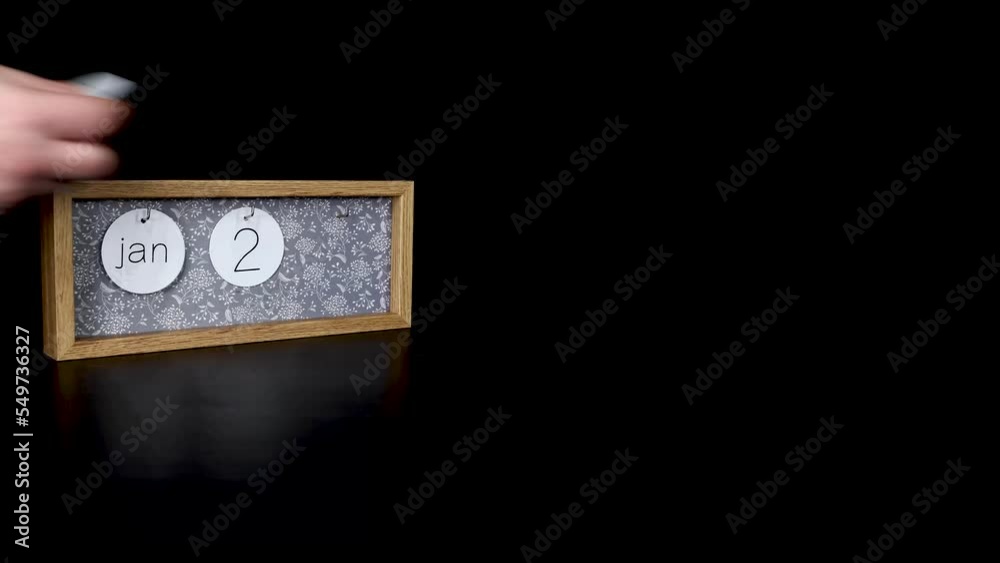 A wooden calendar block showing the date January 28th with a mans hand putting on and taking off the metal discs with the date and month on them, filmed in 4k quality A wooden calendar block showing the date January 28th with a mans hand putting on and taking off the metal discs with the date and month on them, filmed in 4k quality