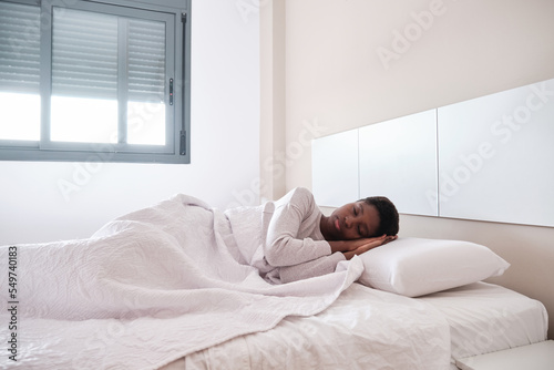 African American female having nap in bedroom