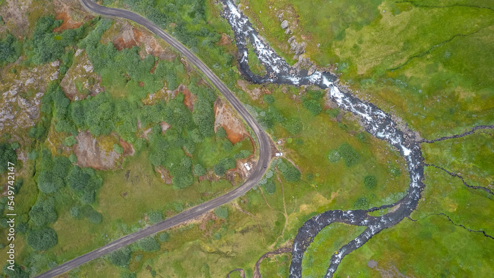 Aerial view of a road along the riverside near Klifbrekku Waterfall in Eastern region of Iceland. Aerial view of a road along the riverside near Klifbrekku Waterfall in Eastern region of Iceland.