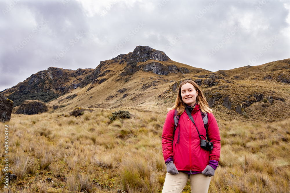 Photo of a happy female hiker looking at camera in the in the Cajas National Park in the highlands of Ecuador, tropical Andes.