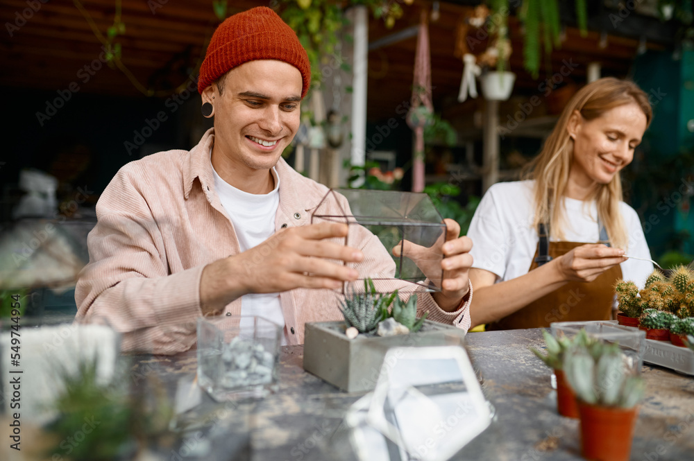 Young florists arranging plants and making florarium Young florists arranging plants and making florarium