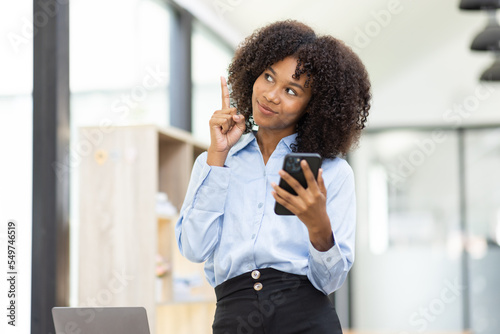 Beautiful asian african businesswoman using phone and sitting at office desk, 