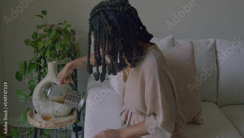 Young woman pouring tea into cup