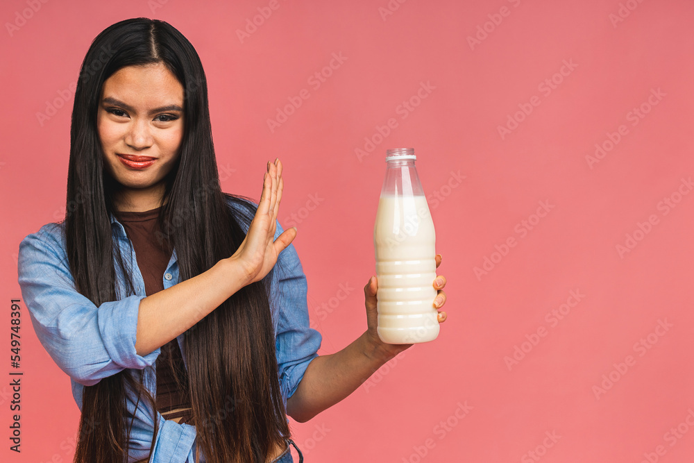 Asian woman's hand holding a bottle of milk and having bad stomach ache