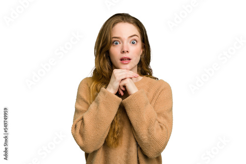 Young caucasian redhead woman isolated praying for luck  amazed and opening mouth looking to front.