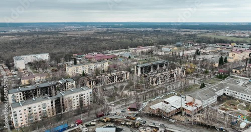 Drone flying over a destroyed district. We can see the roofs of the buildings in the city in ruins - an aerial view with a drone