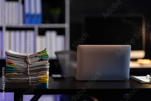 Documents and equipment on the office desk, overtime concept.