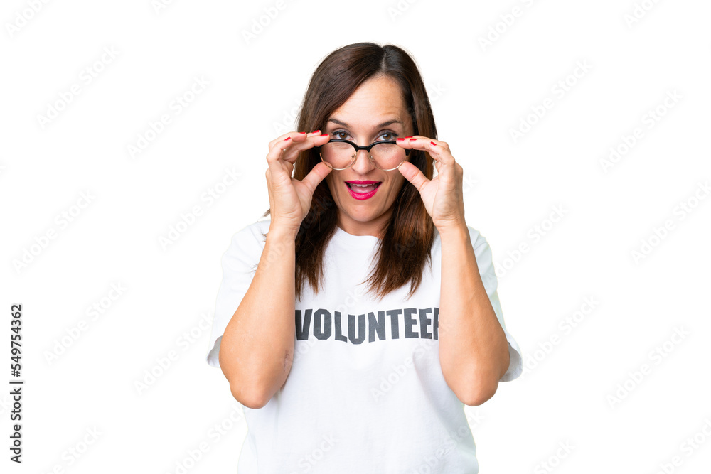 Middle age volunteer woman over isolated chroma key background with glasses and surprised