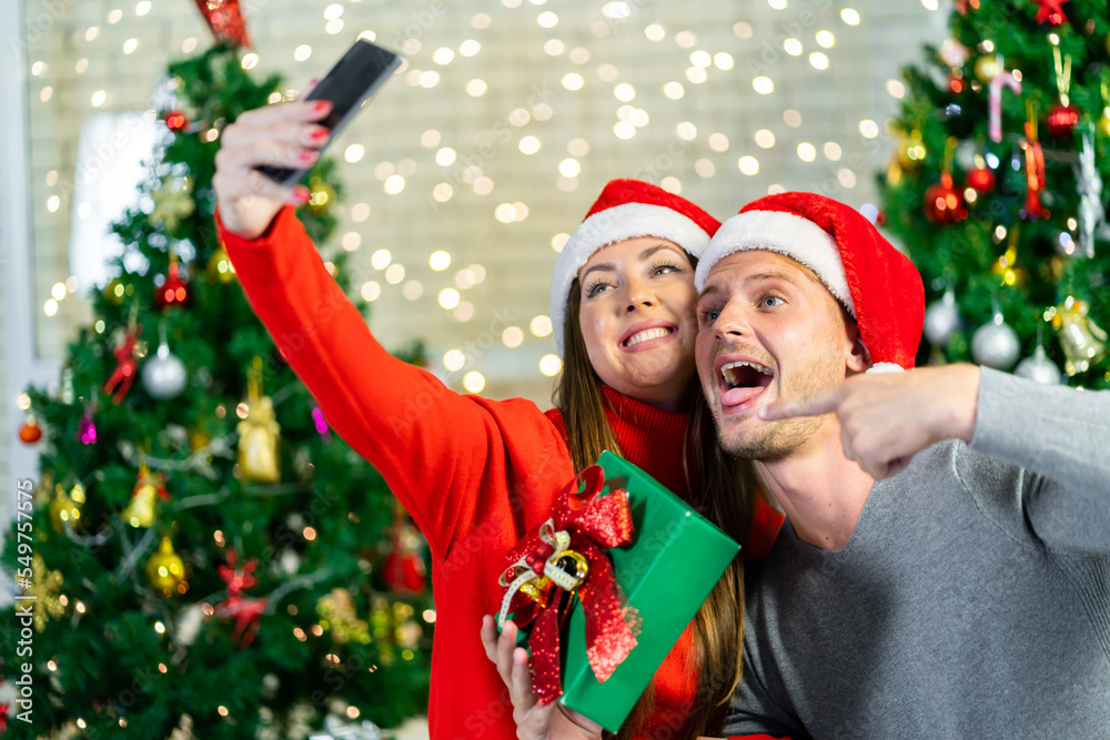 A young couple is celebrating their Christmas together happily at home. A young couple is celebrating their Christmas together happily at home.