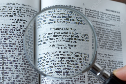 Fototapeta Magnifying glass over open Holy Bible Book