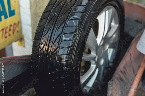 Fotografija Submerging a tire in a soap and water solution to check for leaks or small holes