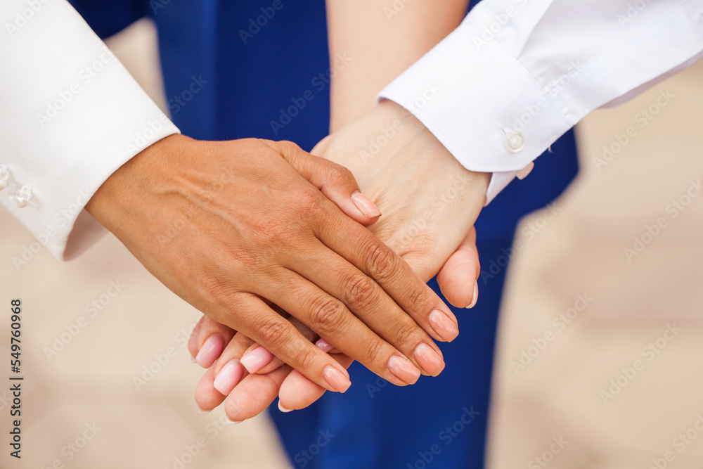 Close-up of business partners making pile of hands at meeting Close-up of business partners making pile of hands at meeting