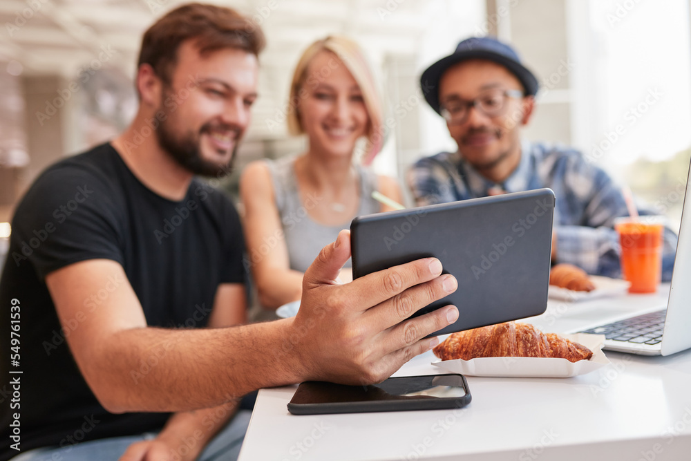 Friends using tablet in restaurant together Friends using tablet in restaurant together