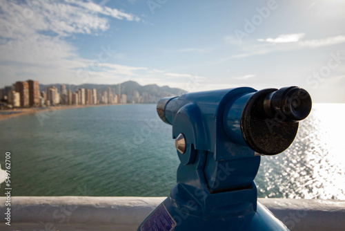 Telescopio del mirador del Balcón del mediterráneo en la zona de Benidorm en Alicante mirando toda la ciudad y su soleado cielo con el tranquilo mar.