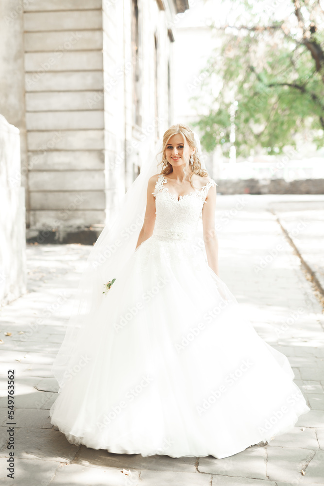 Beautiful bride spinning with perfect dress in the park