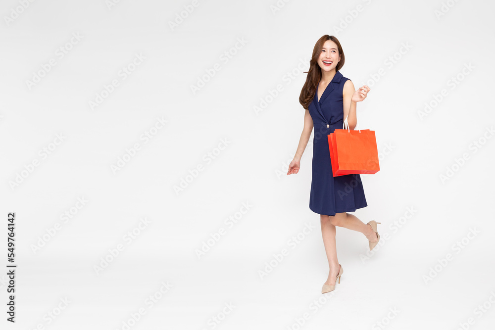 Portrait of Asian woman holding red shopping bags isolated on white background, Shopper or shopaholic concept Portrait of Asian woman holding red shopping bags isolated on white background, Shopper or shopaholic concept