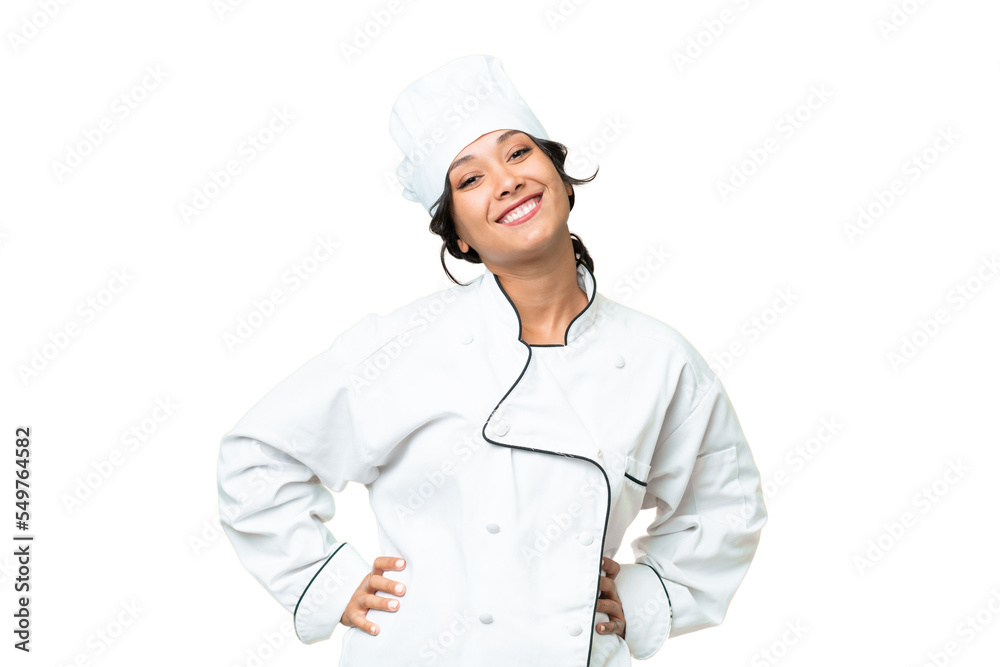 Young chef Argentinian woman over isolated background posing with arms at hip and smiling