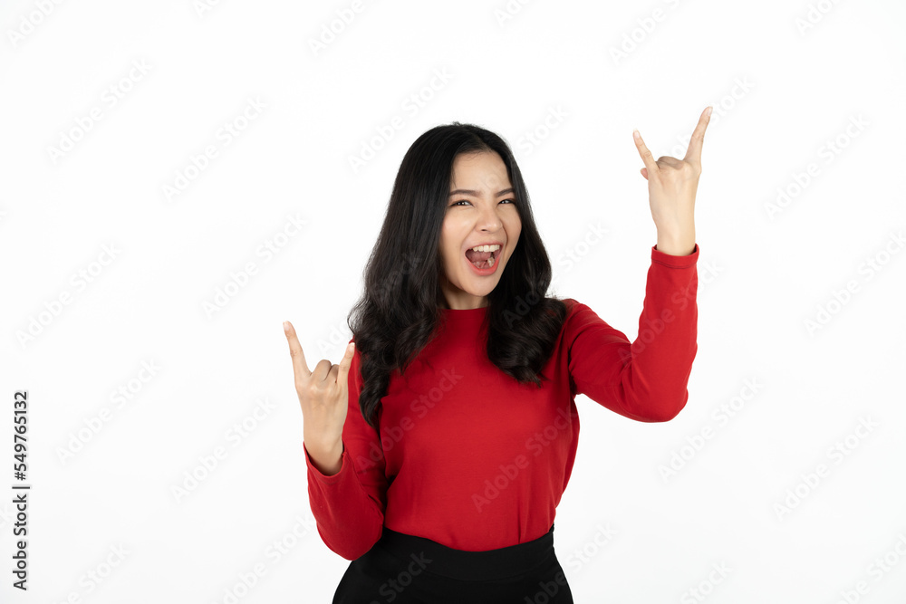 Pleasant looking cheerful woman make rock sign, gestures with both hands, feels rebellious, shows heavy metal, goes wild, listens loud music at home, dressed casually. Asian girl has fun at party Pleasant looking cheerful woman make rock sign, gestures with both hands, feels rebellious, shows heavy metal, goes wild, listens loud music at home, dressed casually. Asian girl has fun at party