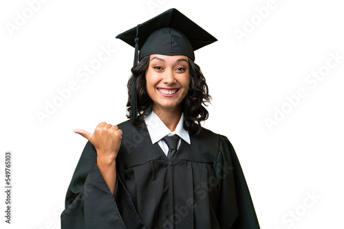 Young university graduate Argentinian woman over isolated background pointing to the side to present a product photo