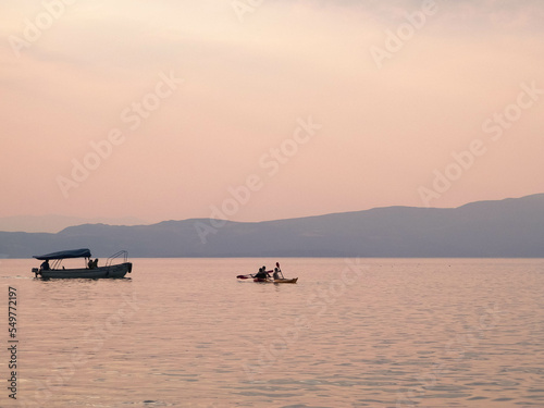 Small boat on Ochrid Lake during sunrise.
