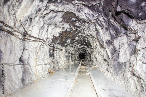 Fototapeta Naklejka Na Ścianę i Meble -  Underground abandoned white calcite marble ore mine shaft tunnel gallery passage with rails