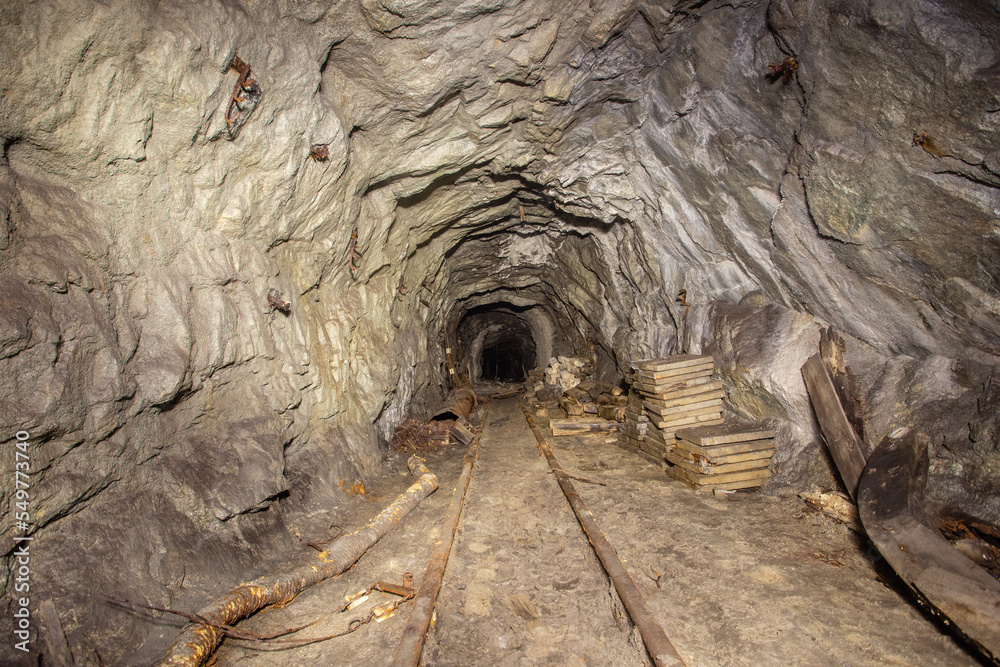 Obraz premium Underground abandoned gold iron ore mine shaft tunnel gallery passage with rails