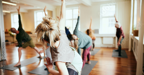 Smiling yoga leading a class in her studio