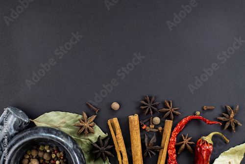 Aromatic spices border on black, top view, space for text