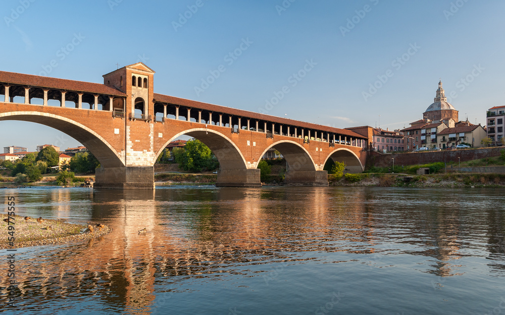 Skyline of Pavia with Ponte Coperto reflecting over the river Ticino in northern Italy