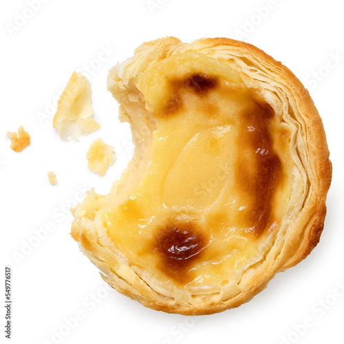 Partially eaten portuguese custard egg tart with crumbs isolated on white from above.